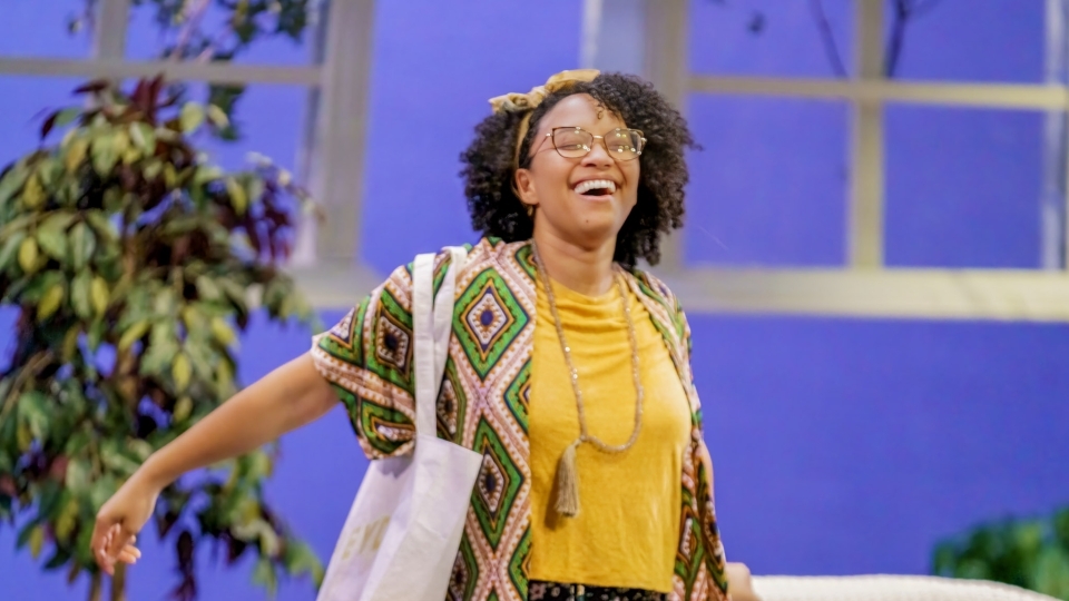 a young woman wearing bright clothes while in a theatre production