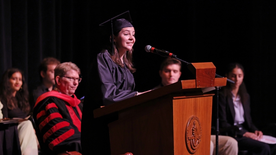 a young woman speaks at a podium 