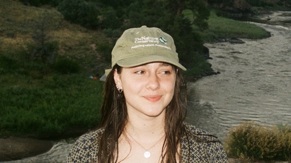 a young white woman smiling wearing a baseball cap