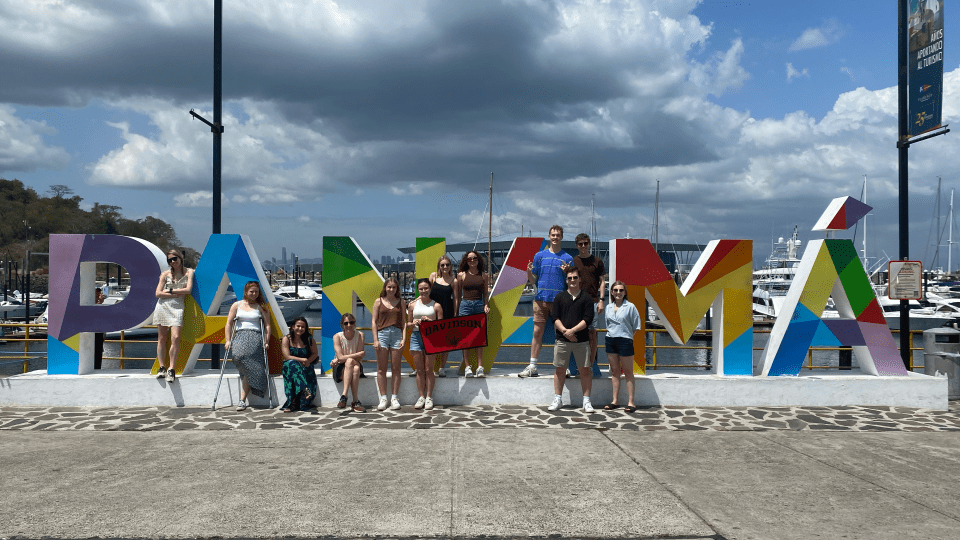 a group of students stand in front of a sign that reads "Panama"