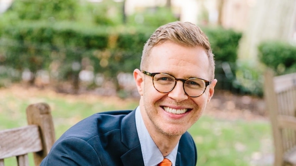 a young white man wearing glasses and suit and tie