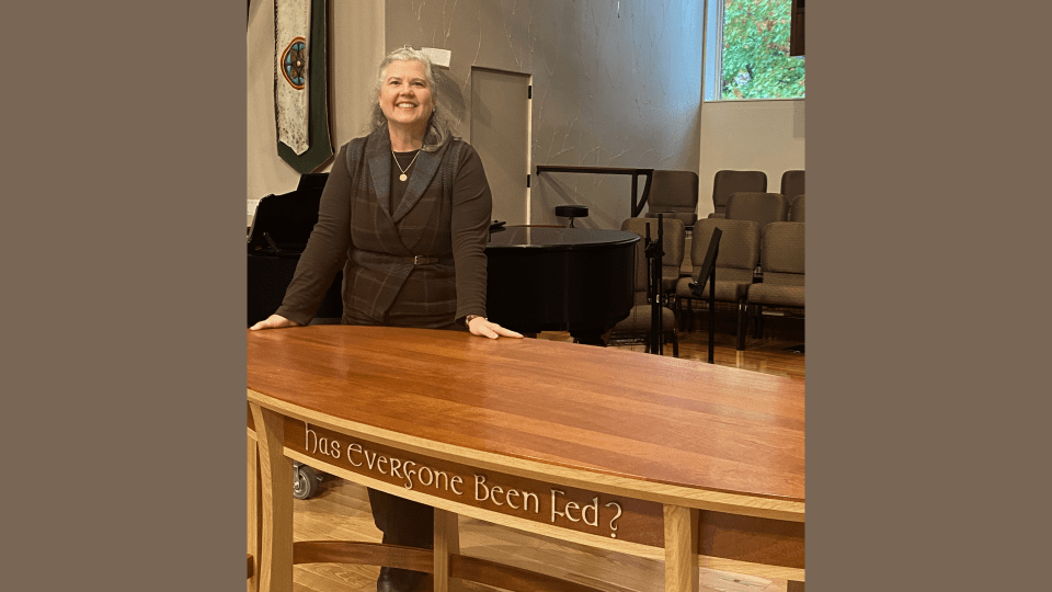 Pastor Mary Katherine Robinson ’93 stands in front of communion table