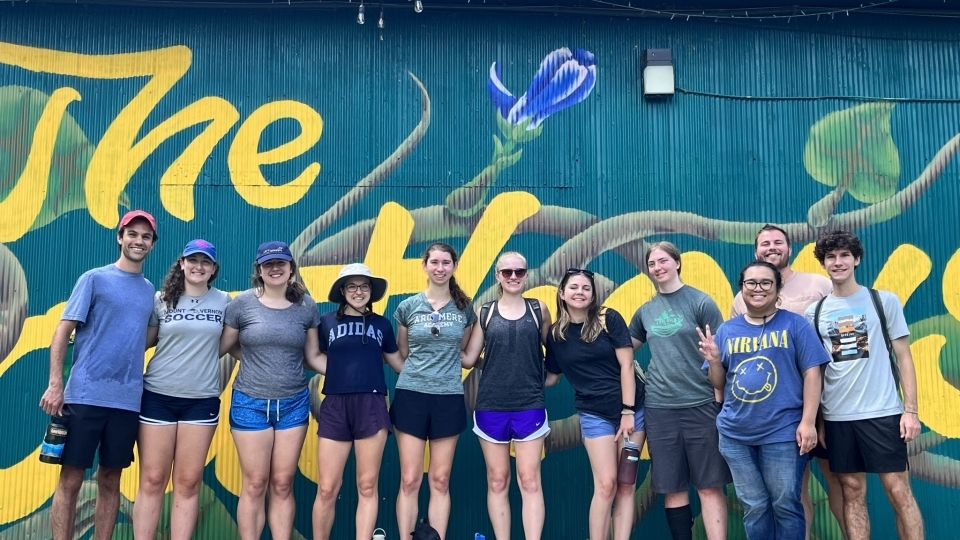 Sustainability Scholars group stands outside against a mural