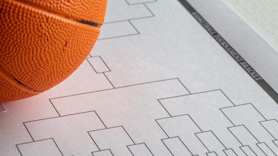 a basketball bracket on a piece of paper with a basketball next to it