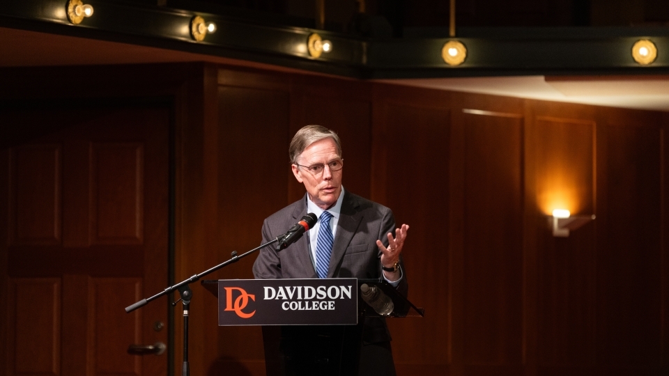 a man speaks into a podium in an auditorium