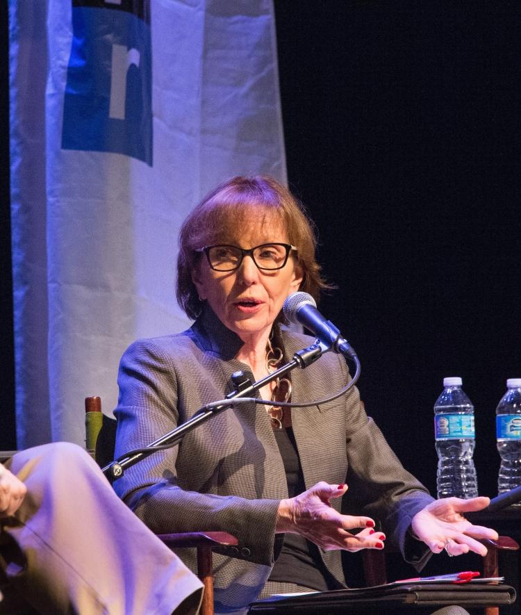 Prof. Susan Roberts sit in on an NPR panel, and speaks into a microphone while seated on stage