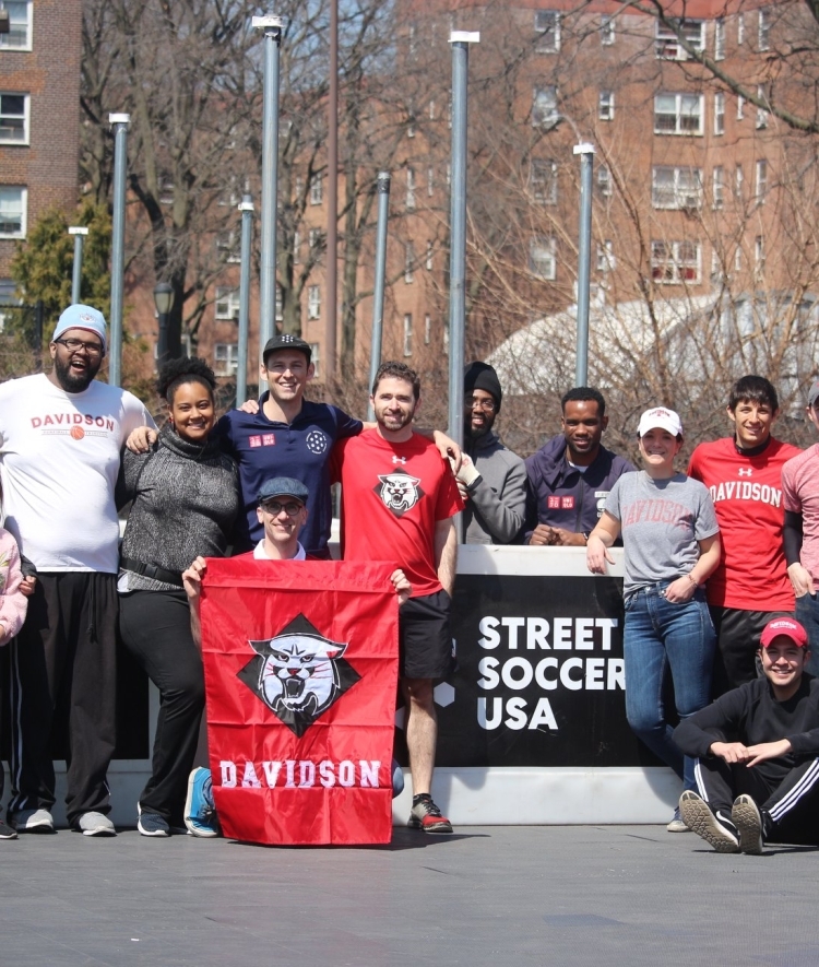 Alumni Group pose holding Davidson flag