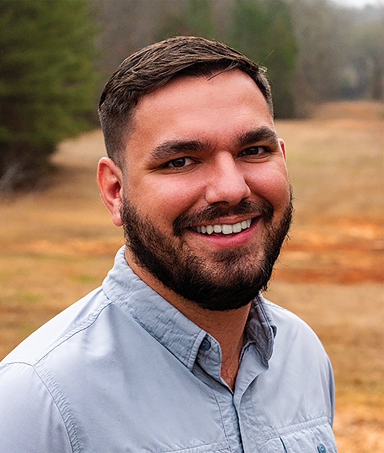 a young Catawba man wearing a collared shirt and smiling