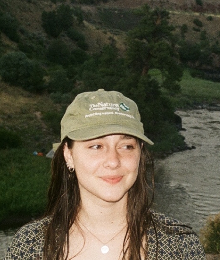 a young white woman smiling wearing a baseball cap