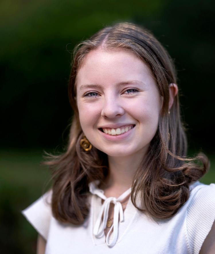 a young white woman wearing a white top