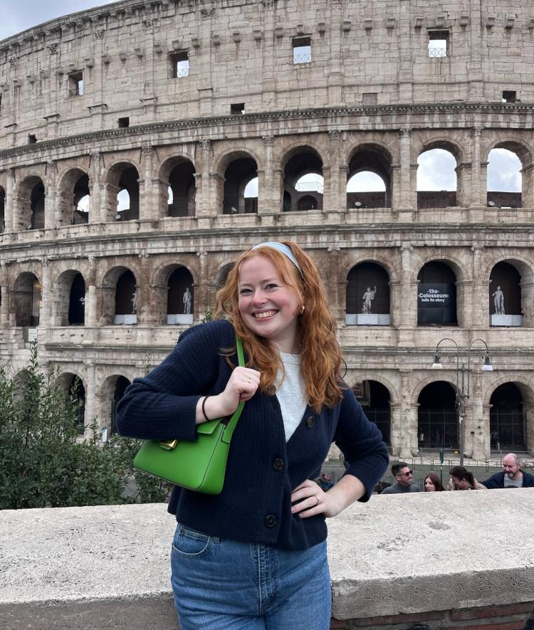 a young woman standing in front of the coliseum