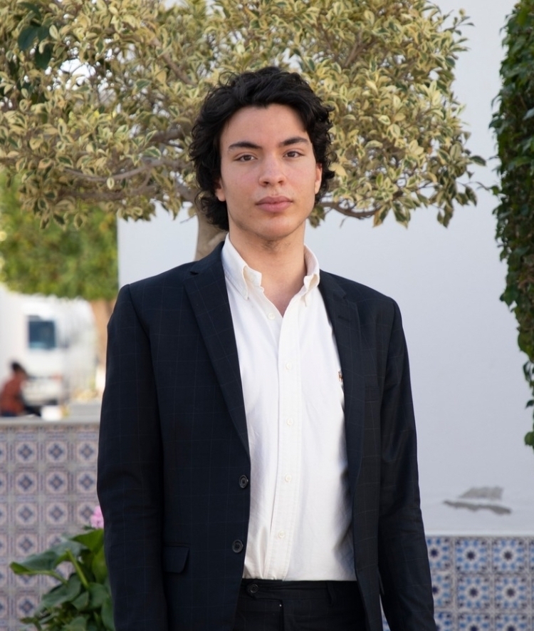 a young man wearing a white collared shirt and black blazer