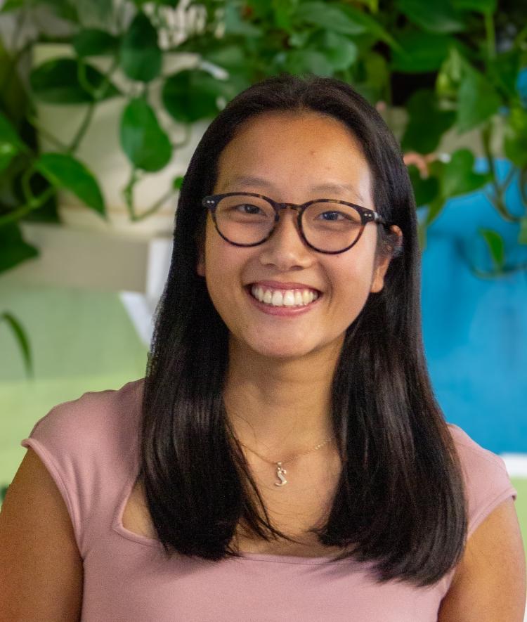 a young Asian woman wearing glasses and smiling