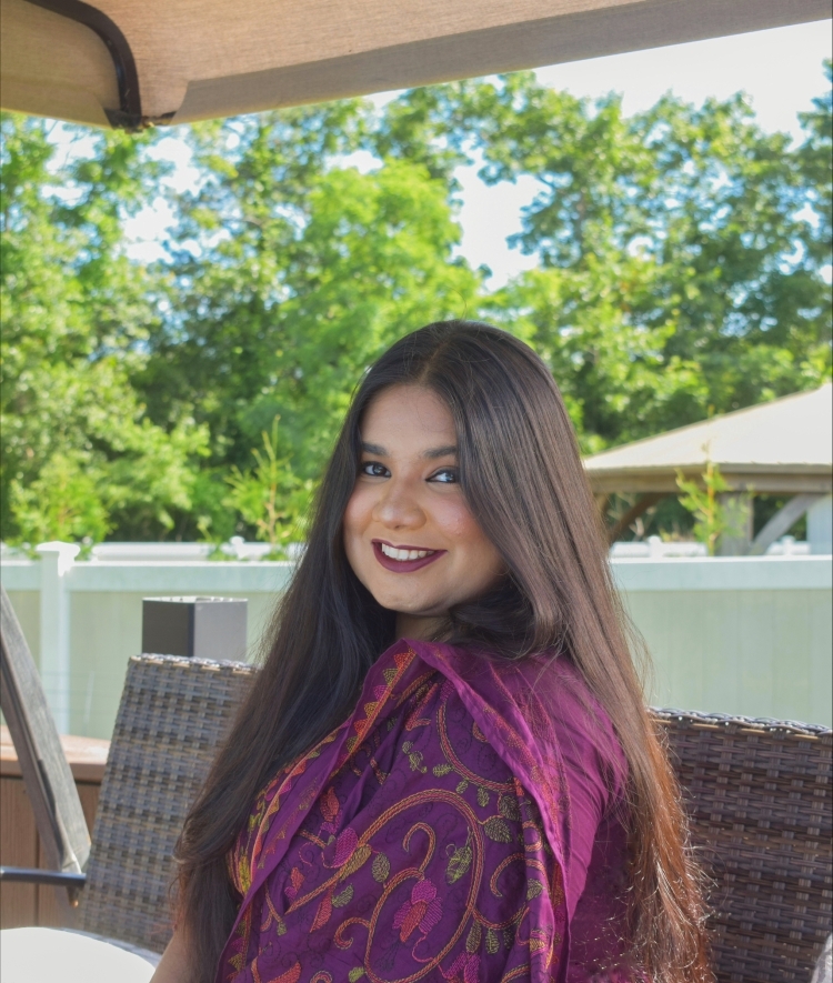 a young woman with long dark hair wearing purple