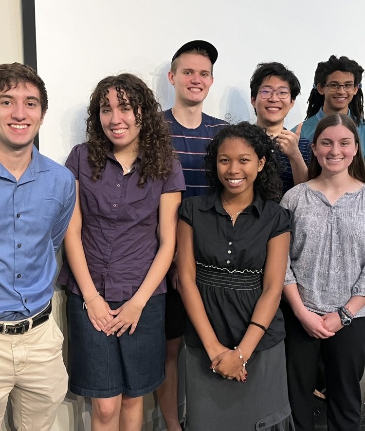 a group of eight students standing together and smiling