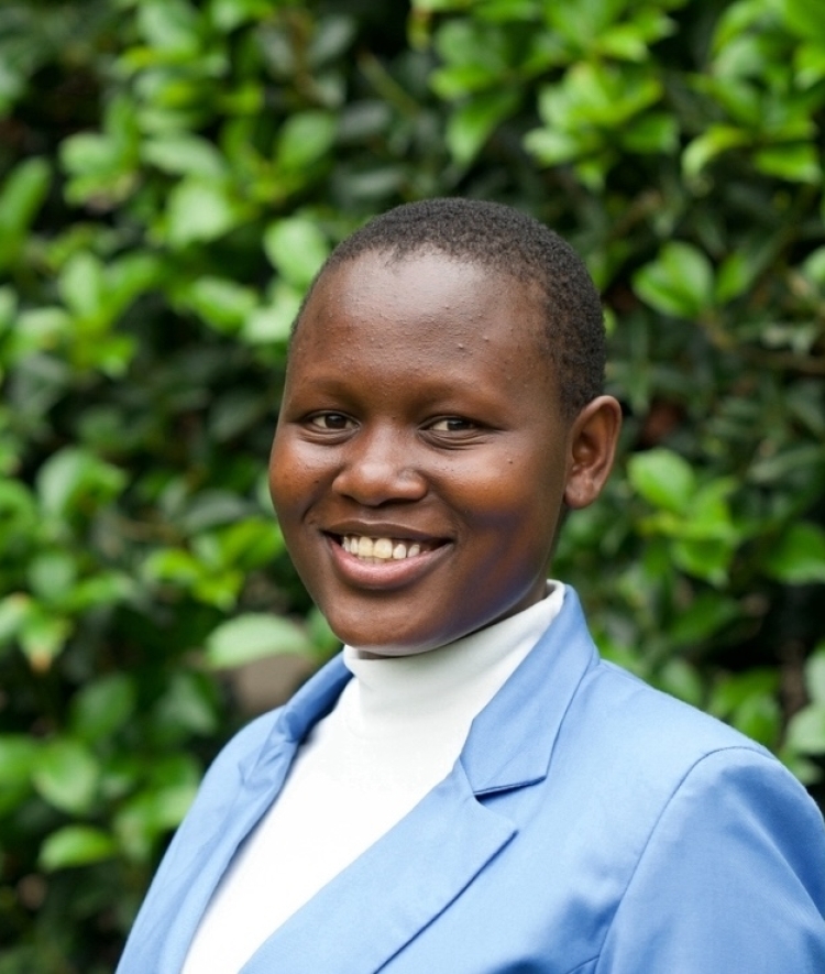 a young African woman wearing a white top and blue blazer