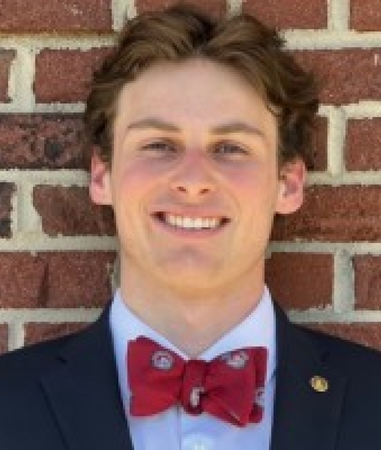 a young white male wearing a red bow tie and smiling