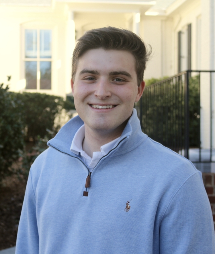 a young white man with brown hair wearing a half zip 