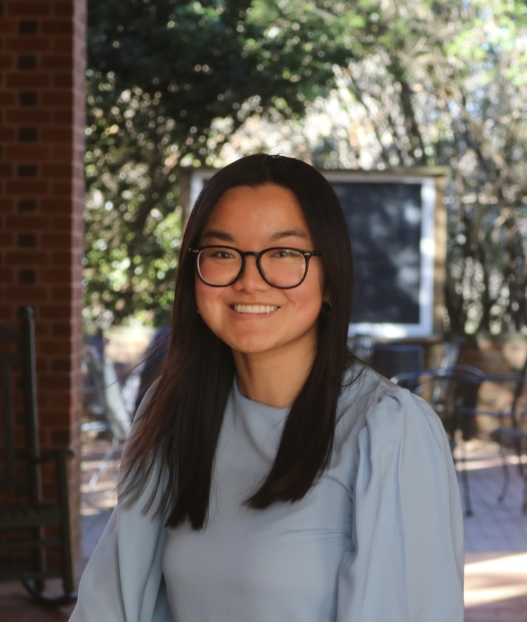 a young woman wearing glasses with blue top 