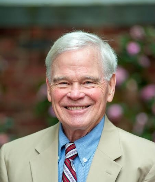 an older white man with white hair wearing a suit and tie