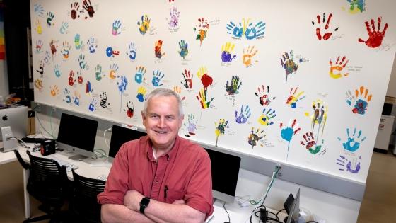 Professor Malcolm Campbell with handprint wall