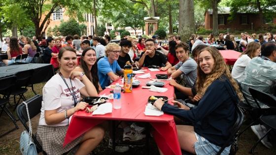 Group of students at a red table at the goodbye luncheon