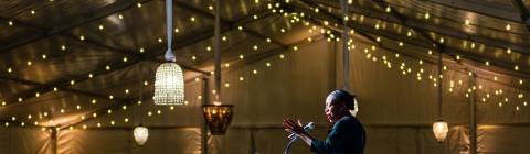 50+ Years of Coeducation speaker at podium in lighted tent