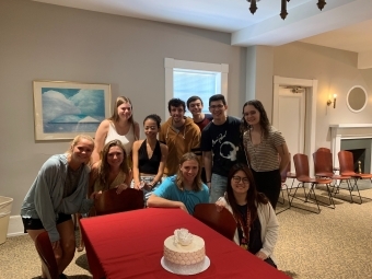 Students pose around a wedding cake