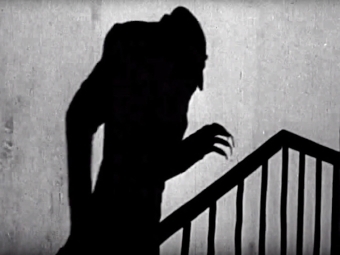 Halloween video screen shot of creepy shadow up the stairs