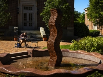 Student studying by art sculpture