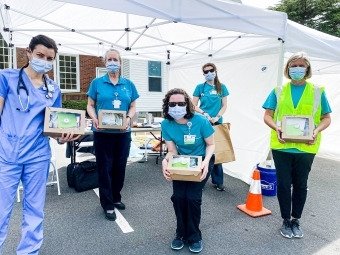 Healthcare Personnel holding lunch boxes