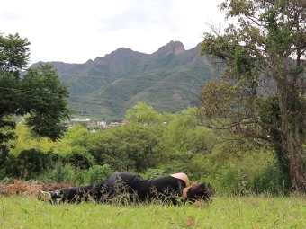 Person laying on ground in green surrounding