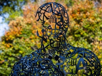 Campus sculpture with fall leaves in the background