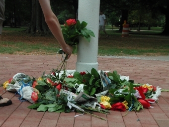 roses and flowers scattered on ground around flagpole in front of Chambers