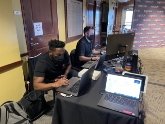 T&I staff working on various computers set up in the 900 room for the event