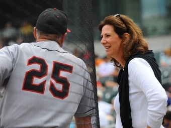 Back of Dick Cooke duriin baseball game with Susan leaning towards him 