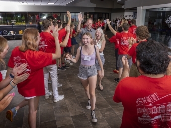 student and family walking through welcome tunnel during Orientation