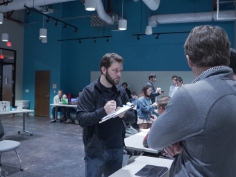 adults and students talk to each other in an innovation center