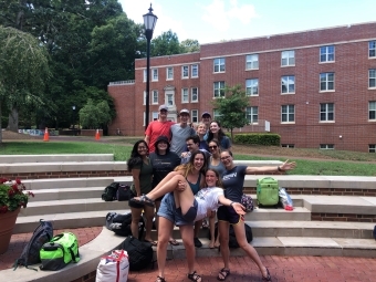 a group of students standing on brick stairs outside on a college campus