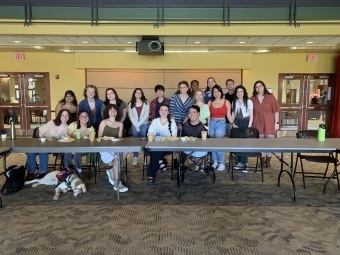 a group of students sit behind a table as part of an event