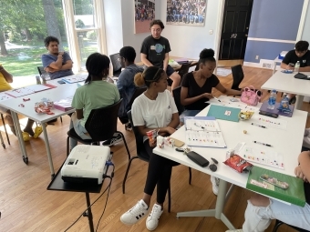 a group of young people in a classroom working at tables together