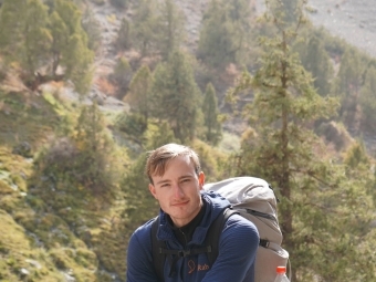 a young man stands in front of a valley