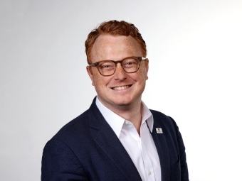 a young white man with red hair wearing glasses