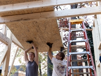 Students lifting plywood together