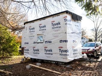 Exterior of tiny house covered in weatherproof plastic