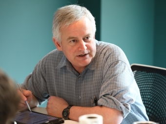 Prof Malcolm Campbell seated in conference room