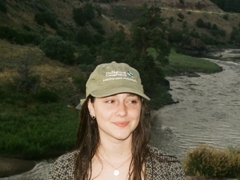 a young white woman smiling wearing a baseball cap