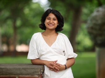 a young woman wearing white standing on a campus