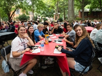 Group of students at a red table at the goodbye luncheon