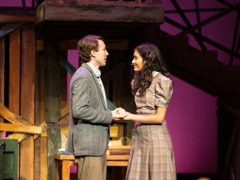 a young man and woman stand together on a stage